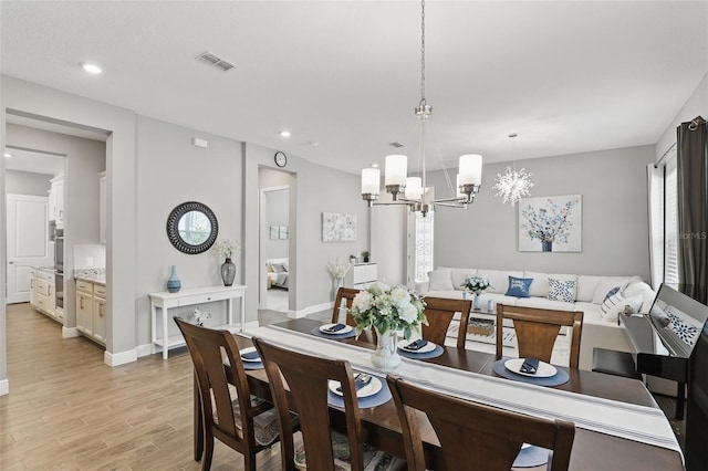 dining room with visible vents, baseboards, recessed lighting, light wood-style floors, and a notable chandelier