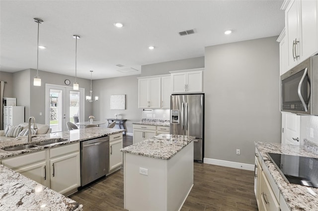 kitchen featuring a sink, stainless steel appliances, visible vents, and dark wood finished floors