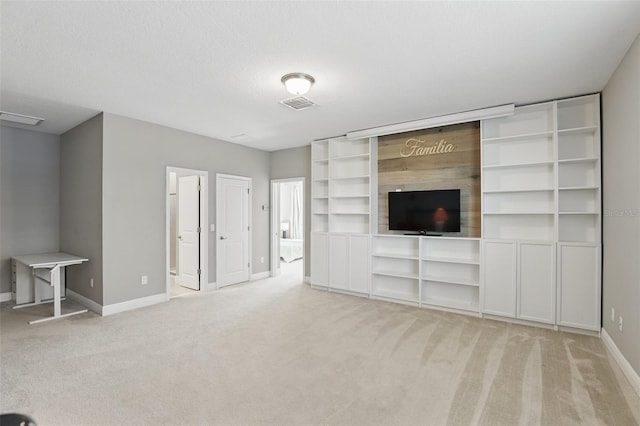 unfurnished living room with baseboards, visible vents, carpet floors, and a textured ceiling