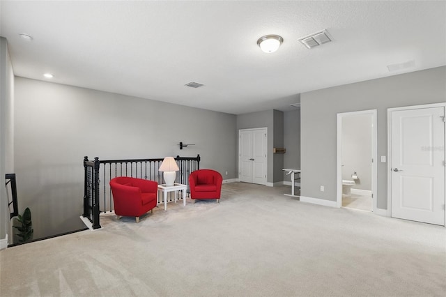 sitting room featuring baseboards, visible vents, and carpet floors