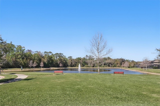 surrounding community featuring a lawn and a water view