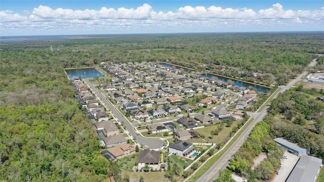 birds eye view of property with a wooded view, a water view, and a residential view