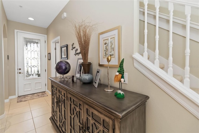 foyer entrance with arched walkways, light tile patterned floors, baseboards, and recessed lighting