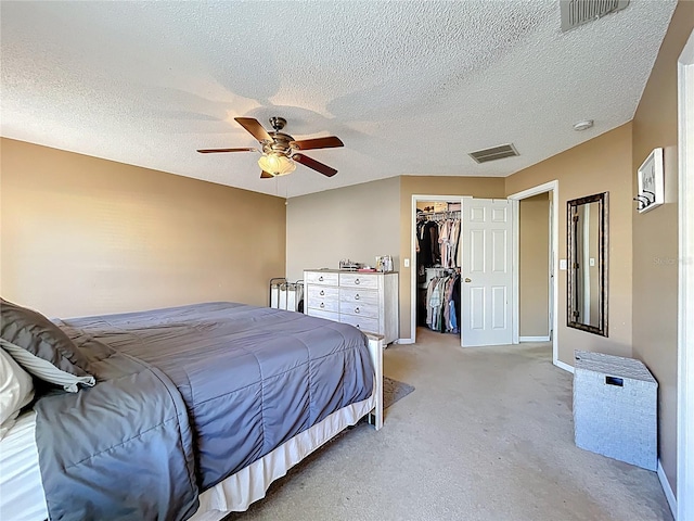 bedroom with a closet, visible vents, ceiling fan, and a textured ceiling