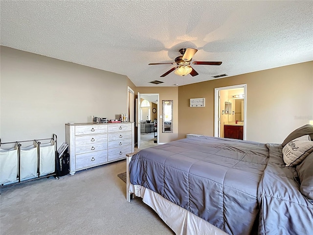 carpeted bedroom featuring a ceiling fan, visible vents, a textured ceiling, and ensuite bathroom