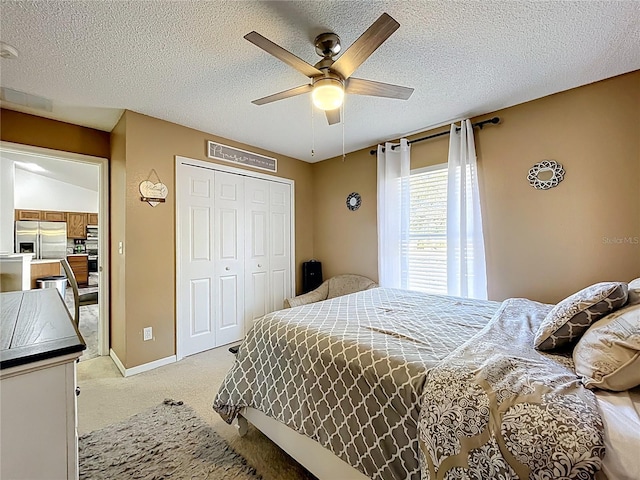 bedroom featuring a closet, light colored carpet, a ceiling fan, a textured ceiling, and stainless steel fridge