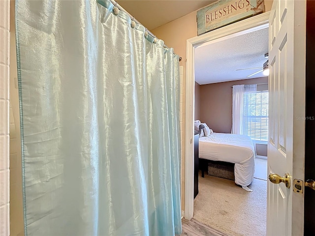 full bath featuring ceiling fan and a textured ceiling