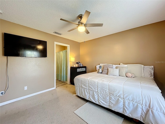 bedroom featuring a ceiling fan, visible vents, a textured ceiling, and baseboards