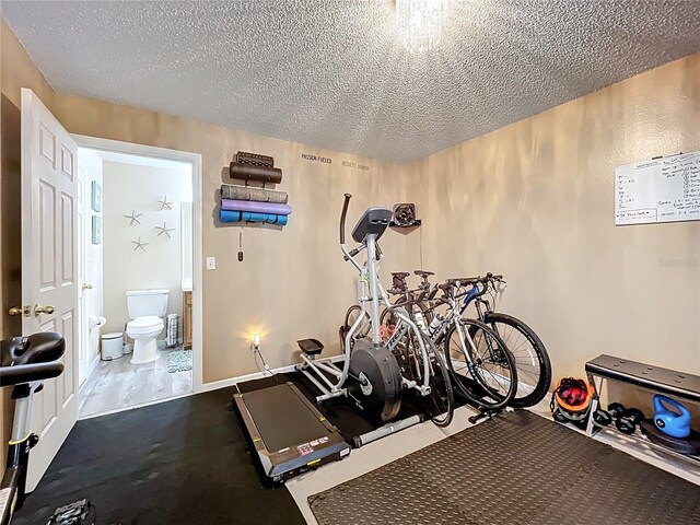 exercise area with a textured ceiling and baseboards