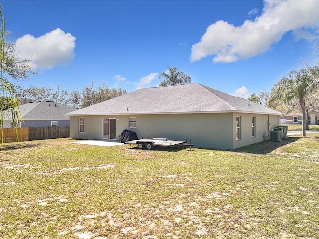 rear view of property featuring a yard, stucco siding, central AC unit, a patio area, and fence