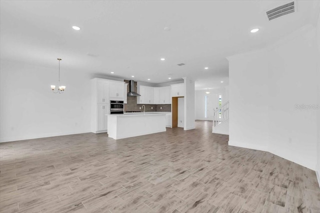 1067 Signet, Apollo Beach, FL 33572 - unfurnished living room featuring a chandelier, recessed lighting, and light wood-style flooring