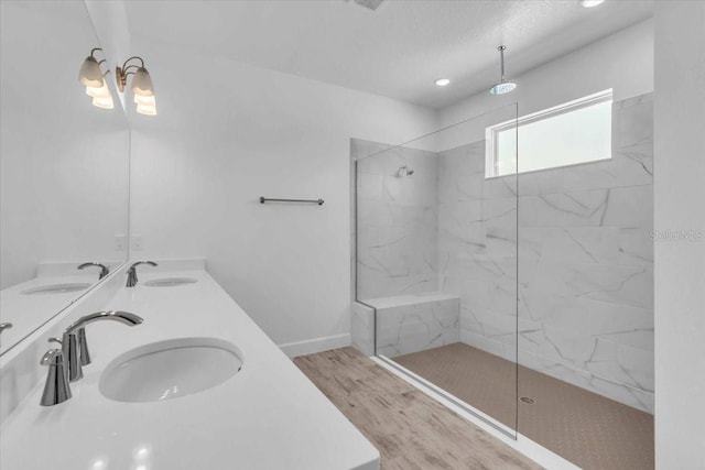 1067 Signet, Apollo Beach, FL 33572 - bathroom featuring wood finished floors, a marble finish shower, a chandelier, double vanity, and baseboards