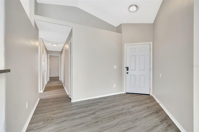 entrance foyer featuring baseboards, vaulted ceiling, and wood finished floors