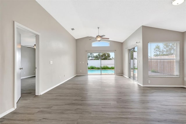 interior space featuring lofted ceiling, ceiling fan, baseboards, and wood finished floors