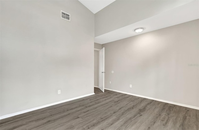 unfurnished room with baseboards, visible vents, and wood finished floors