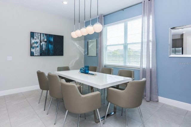 dining space with baseboards and light tile patterned flooring