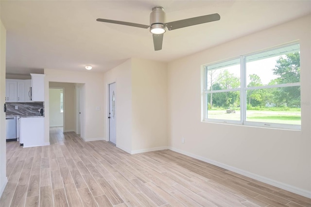 unfurnished living room featuring light wood-style floors, ceiling fan, and baseboards