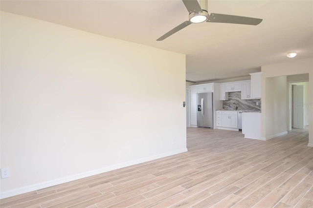 unfurnished living room featuring light wood-type flooring, ceiling fan, and baseboards