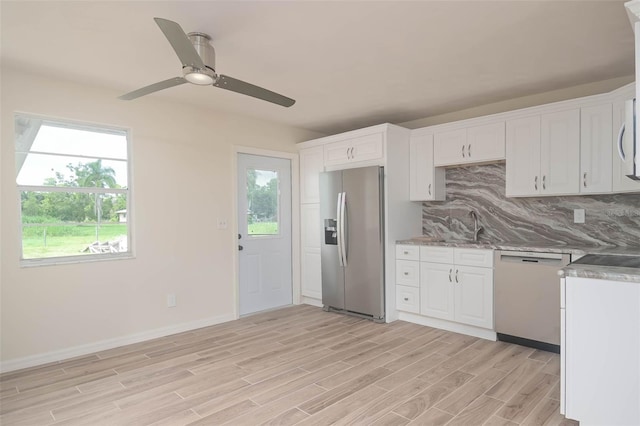 kitchen with stainless steel refrigerator with ice dispenser, backsplash, light wood-style floors, white cabinetry, and dishwasher