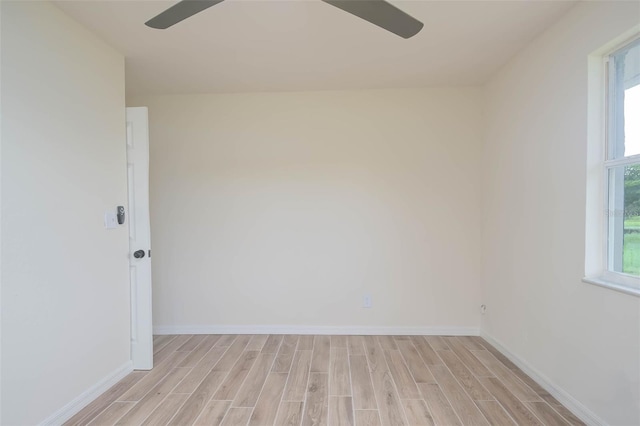 empty room featuring light wood finished floors, plenty of natural light, and a ceiling fan