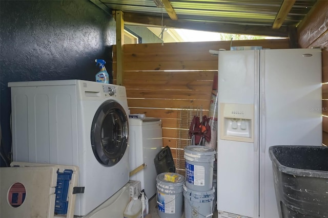 washroom featuring washer / clothes dryer, laundry area, and a textured wall