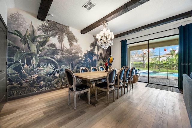 dining room featuring beam ceiling, visible vents, a chandelier, and wood finished floors