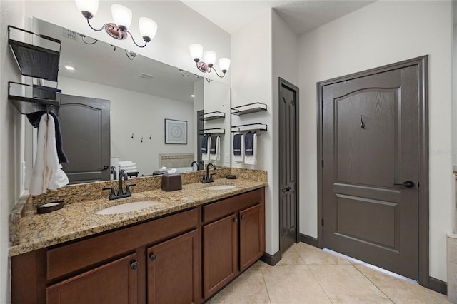 full bath featuring double vanity, baseboards, a sink, and tile patterned floors