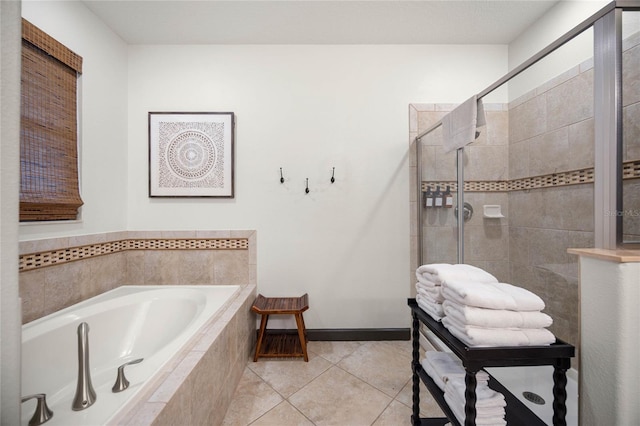 bathroom with tile patterned flooring, a bath, and tiled shower