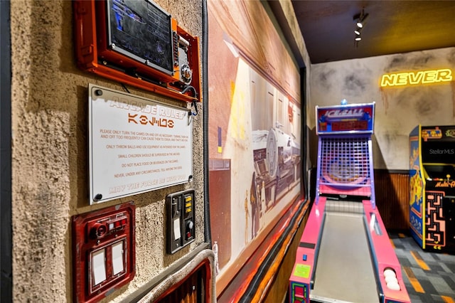 recreation room featuring a wainscoted wall and a bowling alley