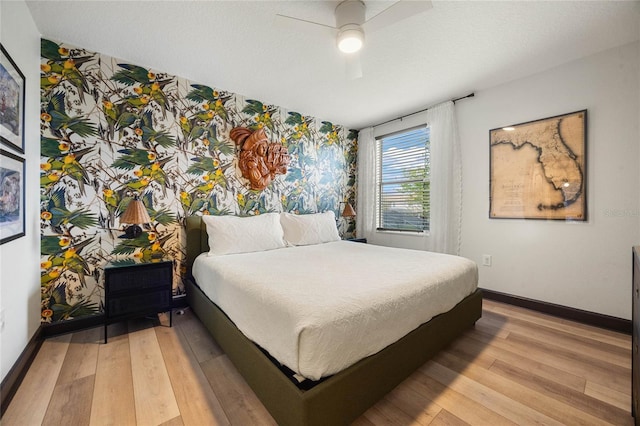 bedroom featuring ceiling fan, light wood-type flooring, and baseboards