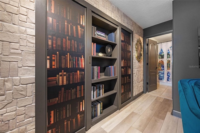 hallway featuring a textured ceiling and wood finished floors