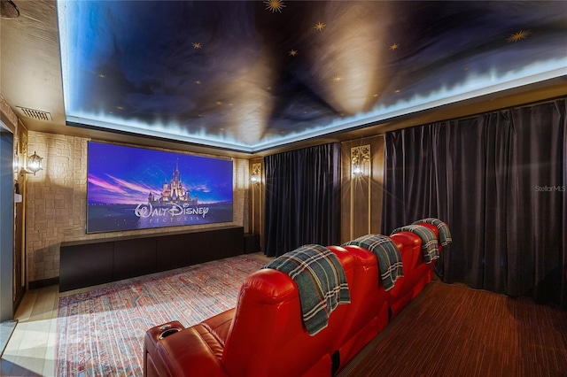 cinema featuring wood finished floors, a raised ceiling, and visible vents