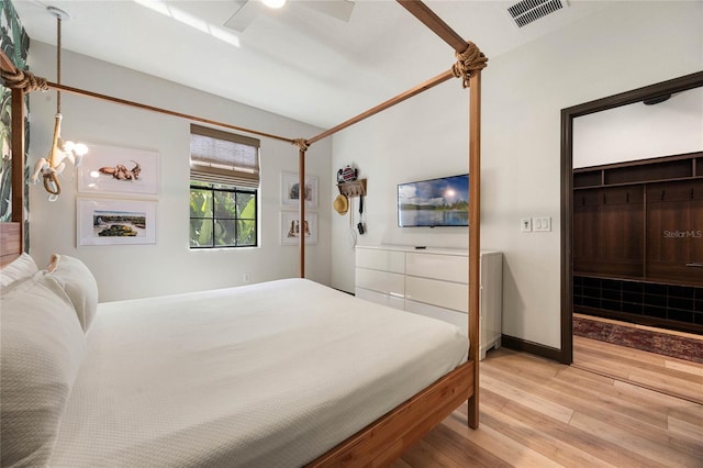 bedroom with light wood-type flooring, ceiling fan, visible vents, and baseboards