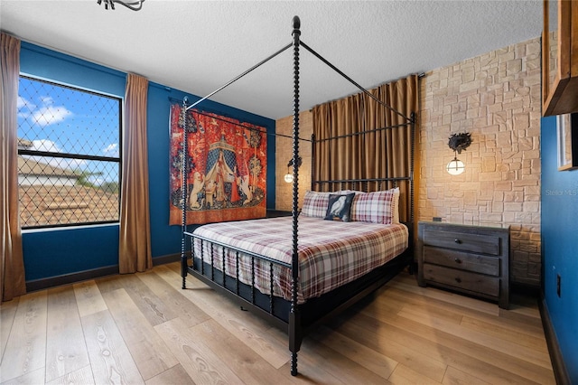 bedroom featuring light wood-style floors and a textured ceiling