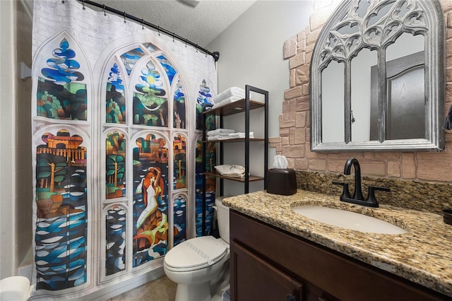 full bathroom with toilet, a textured ceiling, and vanity