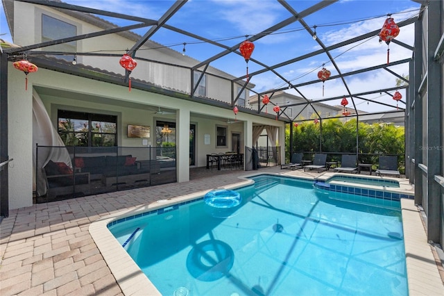 view of pool featuring a ceiling fan, a lanai, a patio area, and a pool with connected hot tub