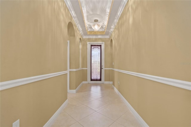 doorway to outside featuring tile patterned floors, baseboards, arched walkways, and crown molding