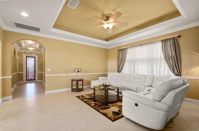 living room with visible vents, a raised ceiling, baseboards, and ornamental molding