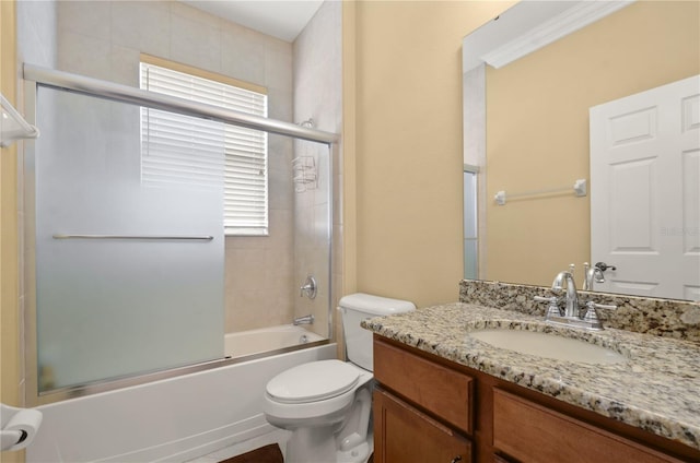 bathroom featuring toilet, vanity, and bath / shower combo with glass door