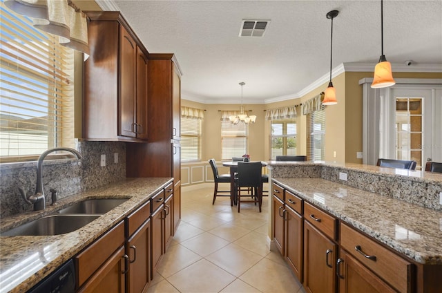 kitchen with visible vents, a sink, pendant lighting, crown molding, and backsplash