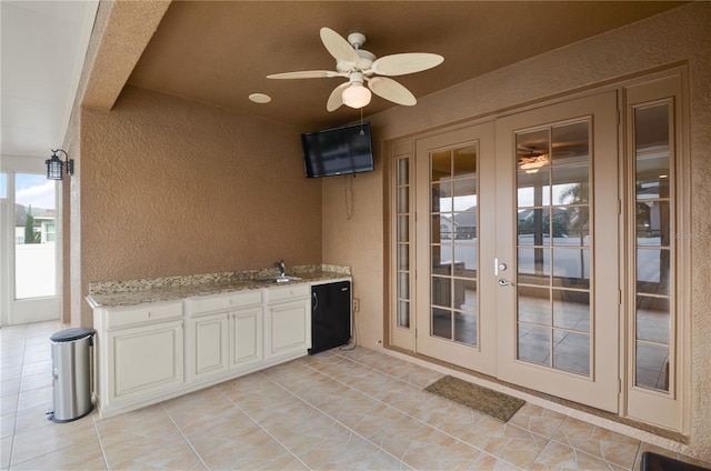 exterior space featuring french doors, ceiling fan, and a sink