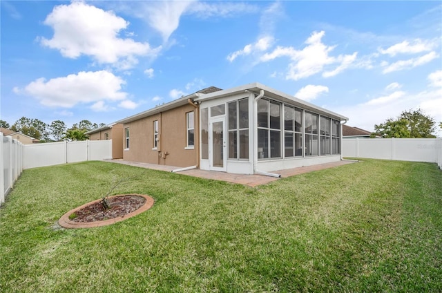 rear view of house with a fenced backyard, a yard, and a sunroom