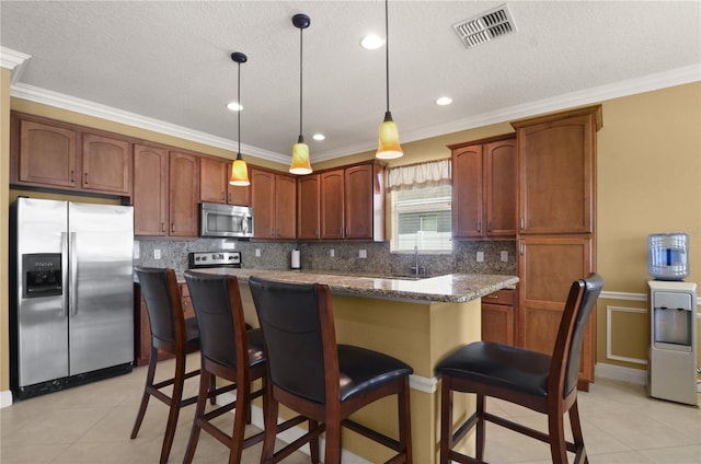 4414 Azure Isle Way, Kissimmee, FL 34744 - kitchen featuring appliances with stainless steel finishes, ornamental molding, a sink, a kitchen island, and light tile patterned flooring