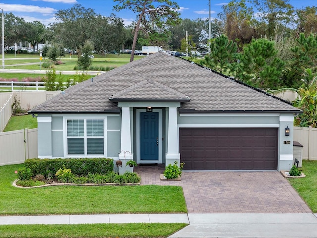 single story home featuring decorative driveway, fence, and a front lawn