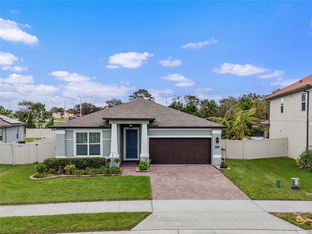 view of front of house with a garage, decorative driveway, a front lawn, and a gate