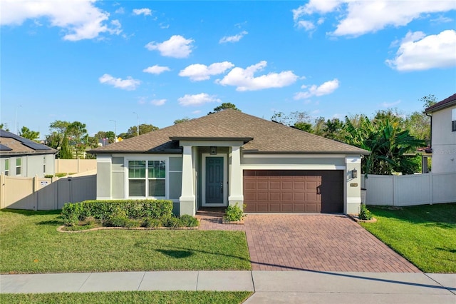 view of front of property featuring a front yard, decorative driveway, fence, and stucco siding