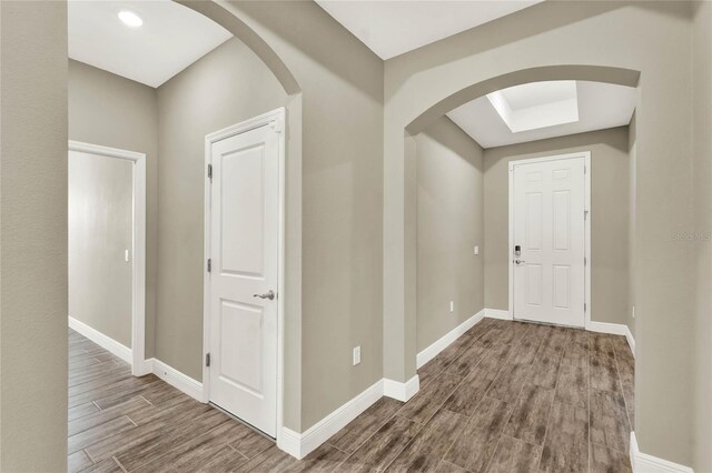 hall featuring baseboards and wood tiled floor