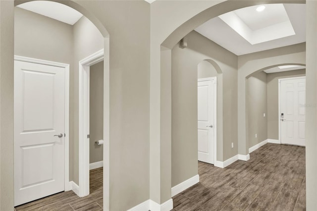 hall with baseboards and wood finished floors