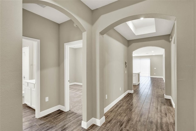 hall featuring baseboards and wood tiled floor