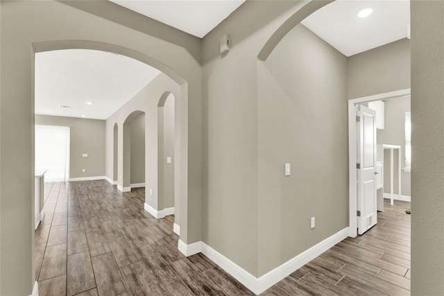 hall featuring recessed lighting, baseboards, and wood finish floors